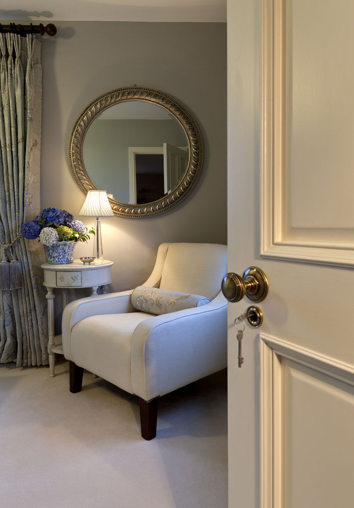 Quiet corner with an armchair and round mirror in a Waterville house